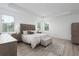 Bright main bedroom offers tray ceilings, wood flooring, and a decorative headboard for a modern yet cozy space at 5651 Trevesta Pl, Palmetto, FL 34221