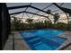 Inviting screened-in pool and hot tub, surrounded by lush tropical landscaping at 5651 Trevesta Pl, Palmetto, FL 34221