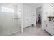 Glass enclosed shower with pebble tile floor adjoins vanity and walk-in closet for a seamless flow at 5651 Trevesta Pl, Palmetto, FL 34221