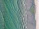 Gorgeous aerial view of crystal-clear ocean waves meeting the pristine sandy beach at 5681 Midnight Pass Rd # 104, Sarasota, FL 34242