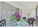 Cozy balcony features a glass-top table, cushioned chairs, and vibrant orchid centerpiece at 5681 Midnight Pass Rd # 104, Sarasota, FL 34242