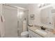 Bathroom with granite vanity top, tiled shower, and decorative mirror at 5681 Midnight Pass Rd # 104, Sarasota, FL 34242