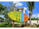 Colorful Siesta Key Village sign with palm trees and condo in background at 5681 Midnight Pass Rd # 104, Sarasota, FL 34242