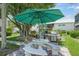 Charming outdoor picnic area with large shade umbrella and stone table and seating, perfect for entertaining at 5681 Midnight Pass Rd # 104, Sarasota, FL 34242