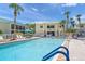 Community pool with lounge chairs, palm trees, and outdoor seating at 5681 Midnight Pass Rd # 104, Sarasota, FL 34242