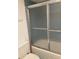 Close-up of bathtub with glass enclosure in bathroom with blue tiled walls at 6124 43Rd W St # 104A, Bradenton, FL 34210