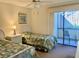 Cozy bedroom featuring twin beds with a nightstand, and access to a sun-soaked balcony at 6124 43Rd W St # 104A, Bradenton, FL 34210