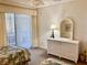 Bright bedroom with twin beds, dresser, and sliding door access to a private balcony with white blinds at 6124 43Rd W St # 104A, Bradenton, FL 34210