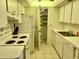 Functional kitchen featuring white appliances and cabinetry offering a bright and clean space, plus an adjoining pantry at 6124 43Rd W St # 104A, Bradenton, FL 34210