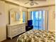 Bright main bedroom featuring a ceiling fan, dresser with mirror, and sliding glass doors to the lanai at 6124 43Rd W St # 104A, Bradenton, FL 34210