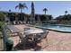 Community pool with lounge chairs, tables, and an umbrella provide a relaxing outdoor experience at 6124 43Rd W St # 104A, Bradenton, FL 34210