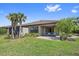 Home's backyard boasts lush green grass, mature landscaping, and a paved patio at 6250 Grandview Hill Ct, Bradenton, FL 34203