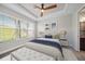 Cozy bedroom features a tray ceiling, natural light, and a comfortable bed with accent pillows at 6250 Grandview Hill Ct, Bradenton, FL 34203