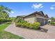 Exterior view of a villa with tile roof, landscaping, brick paver walkway and driveway at 6250 Grandview Hill Ct, Bradenton, FL 34203