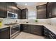 This kitchen features stainless steel appliances, granite counters, tile backsplash, and dark cabinets at 6250 Grandview Hill Ct, Bradenton, FL 34203
