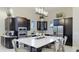 Sleek kitchen featuring stainless steel appliances, dark cabinets, and a spacious quartz countertop island at 6250 Grandview Hill Ct, Bradenton, FL 34203