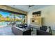 Inviting outdoor lounge with a fireplace and tv overlooking a beautiful pool with lounge seating and palm trees at 6250 Grandview Hill Ct, Bradenton, FL 34203