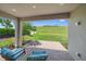 Covered patio with cozy seating area overlooking the beautifully manicured backyard and golf course at 6250 Grandview Hill Ct, Bradenton, FL 34203