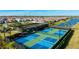 Aerial view of tennis and pickleball courts surrounded by townhomes and a serene lake at 6250 Grandview Hill Ct, Bradenton, FL 34203