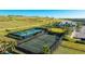 Aerial view of the tennis and pickleball courts with a clubhouse and lush green surroundings at 6250 Grandview Hill Ct, Bradenton, FL 34203