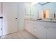 Bright bathroom featuring double sink vanity, and doorway with view of the adjacent room at 6307 Laurel Creek Trl, Ellenton, FL 34222