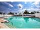 A large community pool with blue lounge chairs and palm trees, perfect for summer relaxation at 6307 Laurel Creek Trl, Ellenton, FL 34222