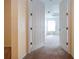 Hallway leading into the main bedroom, showing open doors and carpeted floors in a neutral color palette at 6307 Laurel Creek Trl, Ellenton, FL 34222