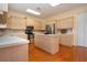 Kitchen with wood floors, island, white countertops, stainless steel fridge and oven at 6307 Laurel Creek Trl, Ellenton, FL 34222