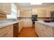 Kitchen with wood floors, island, white countertops, stainless steel fridge and oven at 6307 Laurel Creek Trl, Ellenton, FL 34222
