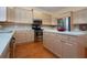 Kitchen with wood floors, island, white countertops, stainless steel fridge and oven at 6307 Laurel Creek Trl, Ellenton, FL 34222