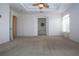Spacious main bedroom with neutral carpet, fan and doors to the ensuite bathroom at 6307 Laurel Creek Trl, Ellenton, FL 34222