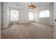 Spacious main bedroom with carpet, ceiling fan, tray ceiling, and three windows with natural lighting at 6307 Laurel Creek Trl, Ellenton, FL 34222