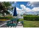 Outdoor picnic area with table and benches beside a scenic lake with a water fountain, perfect for Gathering outings at 6307 Laurel Creek Trl, Ellenton, FL 34222