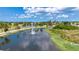 Scenic pond with fountain, lush landscaping, and street bordered by palm trees at 6307 Laurel Creek Trl, Ellenton, FL 34222