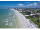Expansive aerial view of a white sand beach, ocean waves, and coastline featuring residential buildings at 6480 Midnight Pass Rd # 311, Sarasota, FL 34242