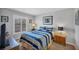Cozy bedroom with a striped bedspread, shuttered window, and nautical decor at 6480 Midnight Pass Rd # 311, Sarasota, FL 34242