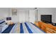 Comfortable bedroom with a striped bedspread, TV, and a large closet at 6480 Midnight Pass Rd # 311, Sarasota, FL 34242