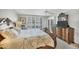 Cozy bedroom featuring a decorative quilt, shuttered windows, and a dresser with a TV at 6480 Midnight Pass Rd # 311, Sarasota, FL 34242