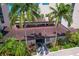 Charming clubhouse with red tile roof amidst lush tropical landscaping at 6480 Midnight Pass Rd # 311, Sarasota, FL 34242