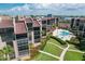 Exterior aerial shows a meticulously landscaped condo complex with a sparkling blue swimming pool at 6480 Midnight Pass Rd # 311, Sarasota, FL 34242