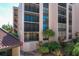 Exterior view of the building with balconies, landscaping, and a peek at the red tile roof at 6480 Midnight Pass Rd # 311, Sarasota, FL 34242