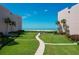 Well-manicured lawn and brick walkway leading to the beach between buildings at 6480 Midnight Pass Rd # 311, Sarasota, FL 34242