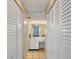 Hallway view leading to bathroom with dual closets providing ample storage space with floral wallpaper and a tiled floor at 6480 Midnight Pass Rd # 311, Sarasota, FL 34242