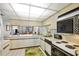 Classic kitchen with white cabinets, an oven, and a view to the living room and the balcony at 6480 Midnight Pass Rd # 311, Sarasota, FL 34242