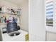 Laundry area with appliances, storage shelving, and bright light from the window at 6480 Midnight Pass Rd # 311, Sarasota, FL 34242
