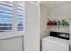 Laundry room with washer and dryer hookups, shelving and shuttered window at 6480 Midnight Pass Rd # 311, Sarasota, FL 34242