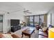 Bright living room featuring a ceiling fan, TV, leather couches, and a balcony overlooking the beach at 6480 Midnight Pass Rd # 311, Sarasota, FL 34242