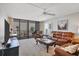 Well-lit living room with balcony access, featuring leather seating, a desk, and an entertainment center at 6480 Midnight Pass Rd # 311, Sarasota, FL 34242