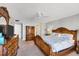 Spacious main bedroom with a beautifully carved wooden bed frame, classic dressers, a ceiling fan, and carpet flooring at 6480 Midnight Pass Rd # 311, Sarasota, FL 34242