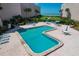 Community pool surrounded by lounge chairs and tables, set against the backdrop of the ocean at 6480 Midnight Pass Rd # 311, Sarasota, FL 34242